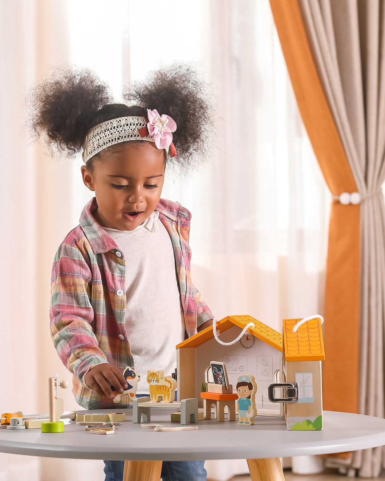 toddler girl playing with vet play set in the room