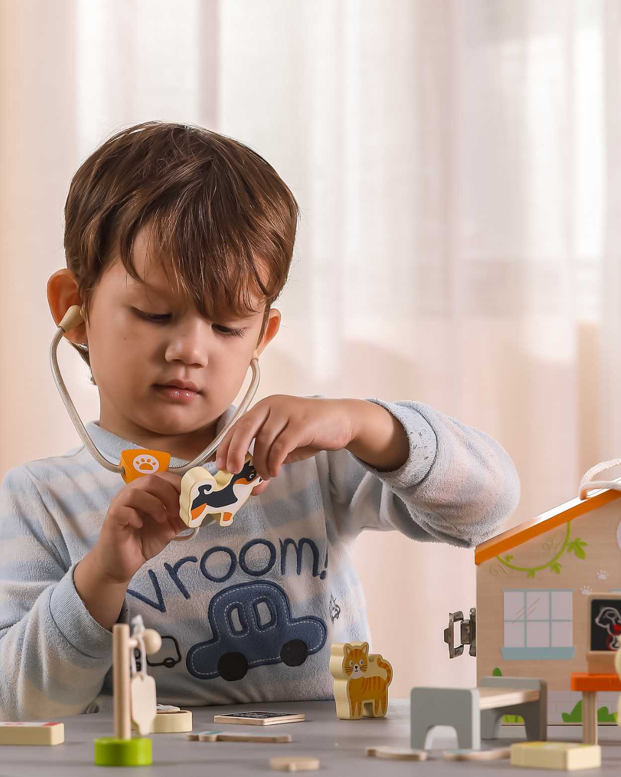 toddler boy playing with vet playset